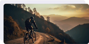 A man riding a bike traverses a mountainous lanscape.